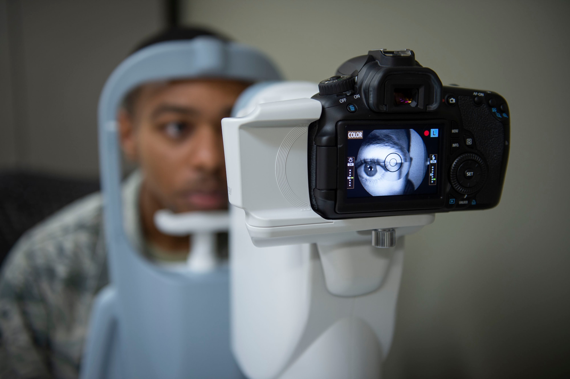 A patient looks through a fundus camera during a retinal examination at Moody Air Force Base, Georgia, Oct. 17, 2019. Optometry technicians perform yearly eye exams to assess Airmen’s vision  and look for signs of eye disorders such as cataracts or glaucoma. The 23d Medical Group optometry clinic is responsible for maintaining Airmen’s ability to see and provides eyewear to those with vision impairments. (U.S. Air Force photo by Airman Azaria E. Foster)