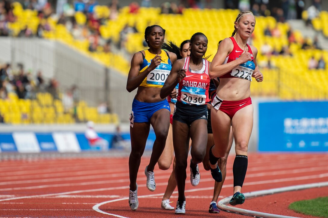 An Air Force runner leads a group of racers on a track.