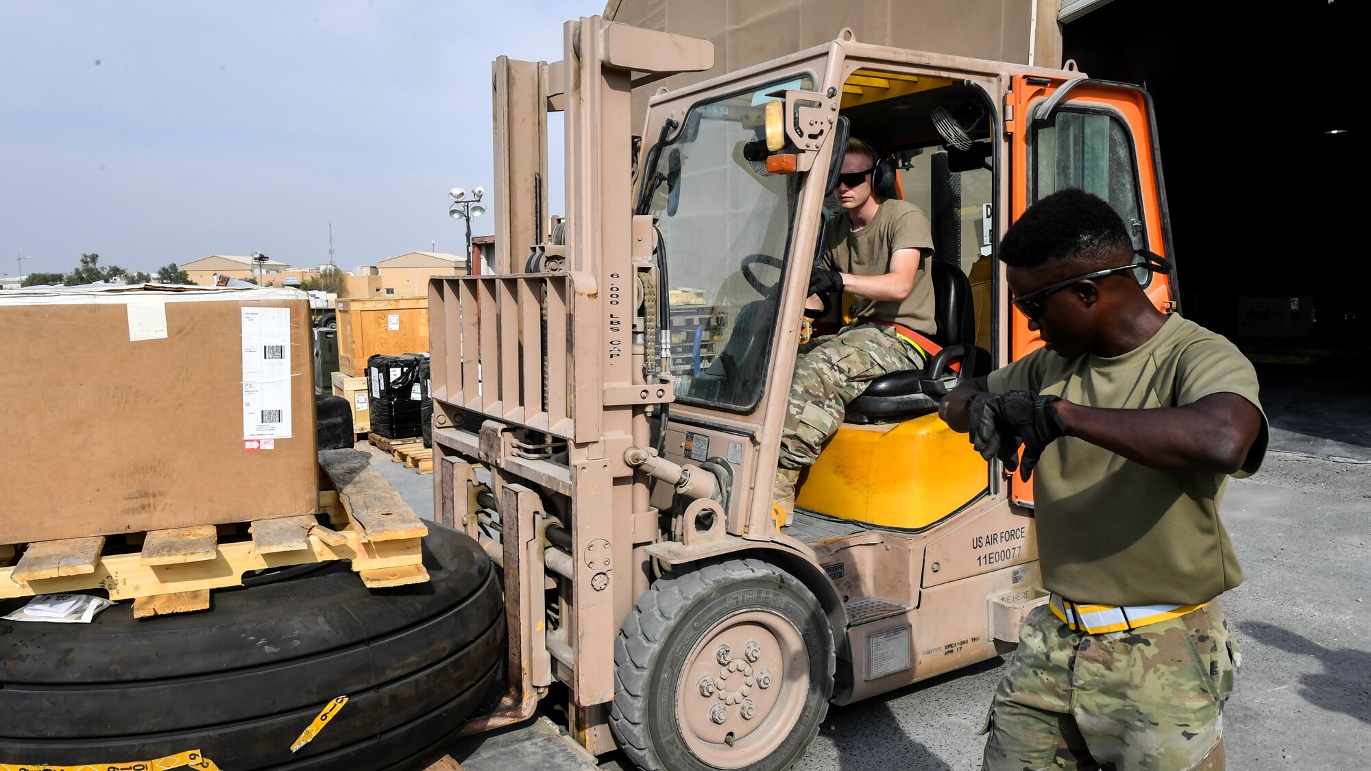 Staff Sgt. Earl Devaughn, 386th Expeditionary Logistics Readiness Squadron aerial port cargo processing representative, uses hand signals to guide Senior Airman Dalton McWilliams, 386th ELRS aerial port cargo processing representative, as he drives a forklift at Ali Al Salem Air Base, Kuwait, Oct. 17, 2019. Port Dawgs are responsible for inspecting and building cargo pallets and leading the cargo onto outbound aircraft, which supply various locations within the U.S. Central Command area of responsibility