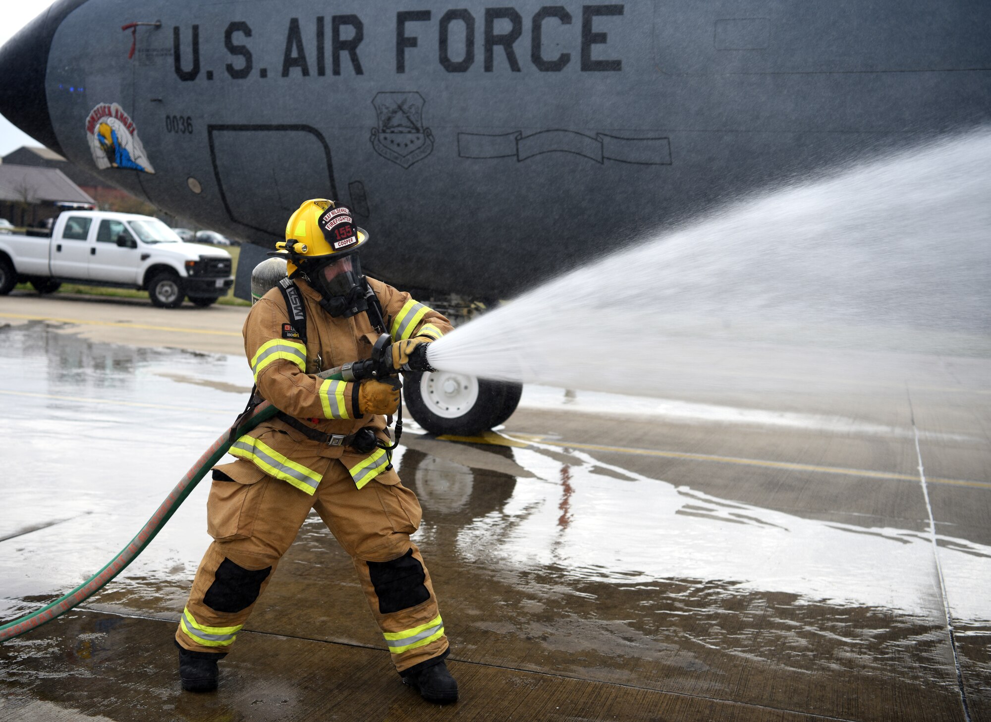 A firefighter with the 100th Civil Engineer Squadron sprays water on a KC-135 Stratotanker engine during a training exercise simulating a cockpit fire at RAF Mildenhall, England, Oct. 22, 2019. The firefighters had to search for “unaccounted personnel” in and around the aircraft during the simulated fire. (U.S. Air Force photo by Senior Airman Brandon Esau)