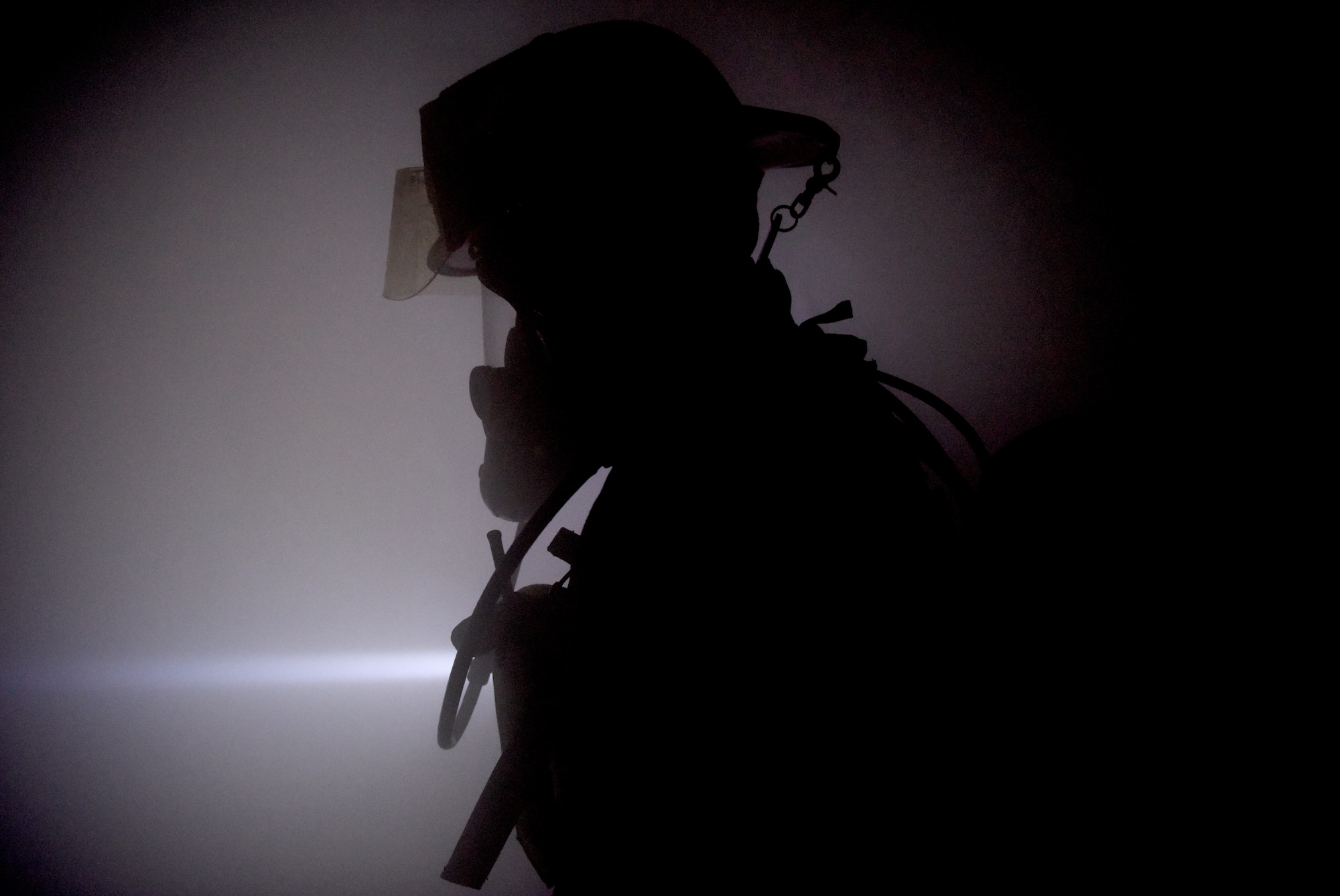 A firefighter with the 100th Civil Engineer Squadron searches for unaccounted personnel aboard a KC-135 Stratotanker during a training exercise simulating a cockpit fire at RAF Mildenhall, England, Oct. 22, 2019. Hands-on training is performed quarterly by the fire department to help keep firefighters familiar with the interior layout of the aircraft and proper shut-down procedures. (U.S. Air Force photo by Senior Airman Brandon Esau)