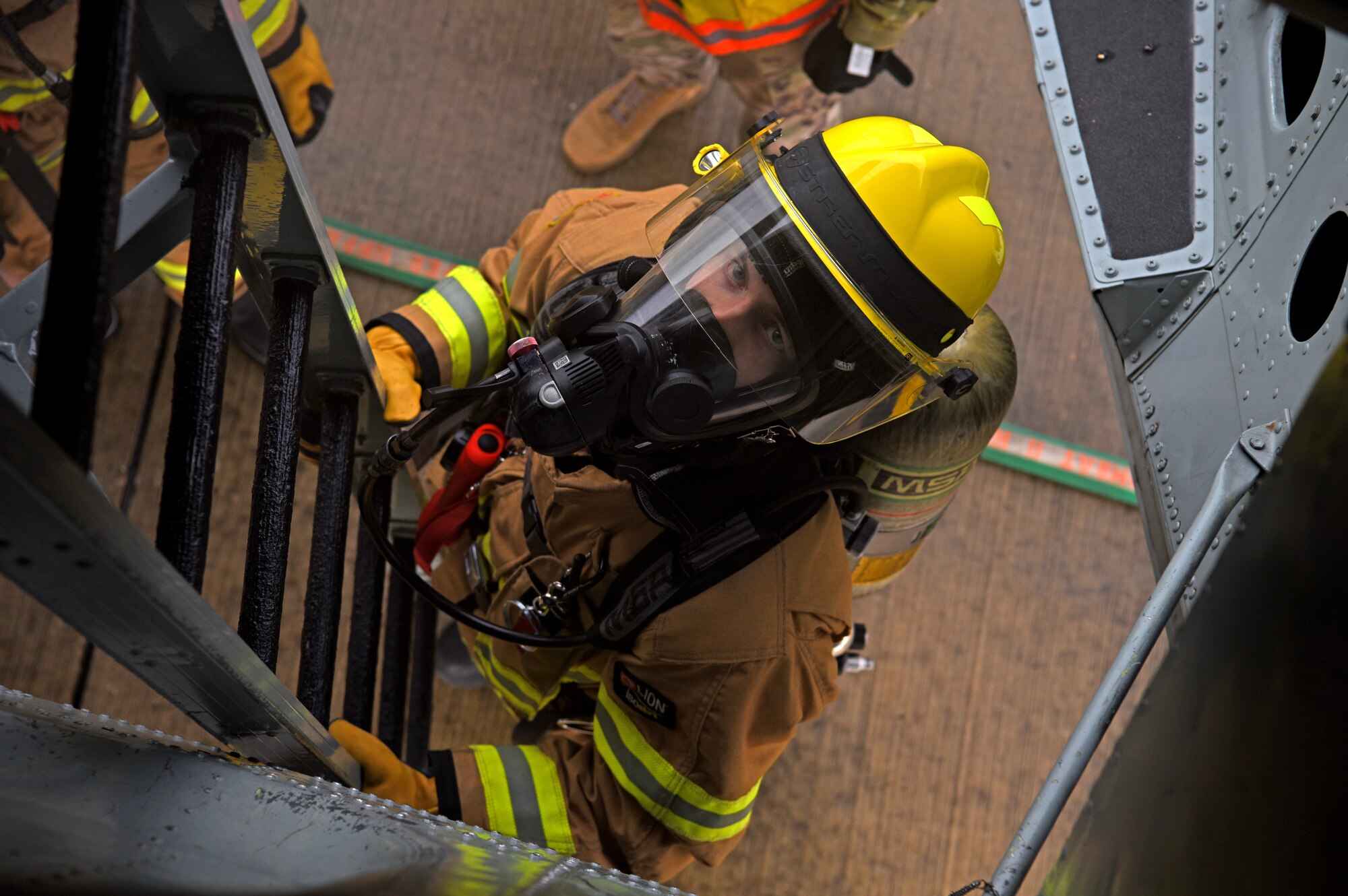 A firefighter with the 100th Civil Engineer Squadron practices attaching a chute ladder to a KC-135 Stratotanker during a training exercise simulating a cockpit fire at RAF Mildenhall, England, Oct. 22, 2019. The firefighters had to search for “unaccounted personnel” in and around the aircraft during the simulated fire. (U.S. Air Force photo by Senior Airman Brandon Esau)