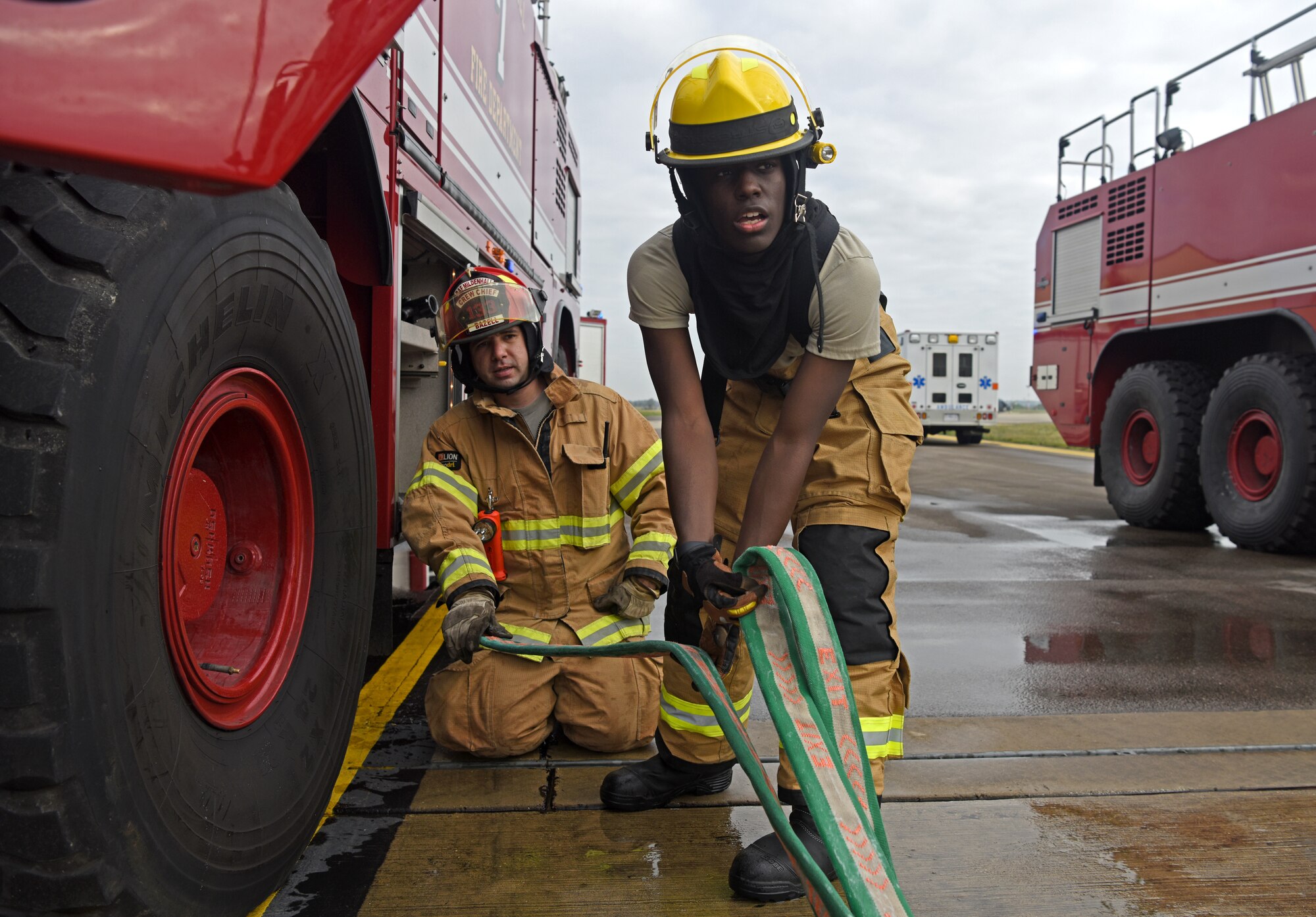 Firefighters with the 100th Civil Engineer Squadron secure a hose during a training exercise simulating a cockpit fire aboard a KC-135 Stratotanker at RAF Mildenhall, England, Oct. 22, 2019. Hands-on training is performed quarterly by the fire department to help keep firefighters familiar with the interior layout of the aircraft and proper shut-down procedures. (U.S. Air Force photo by Senior Airman Brandon Esau)