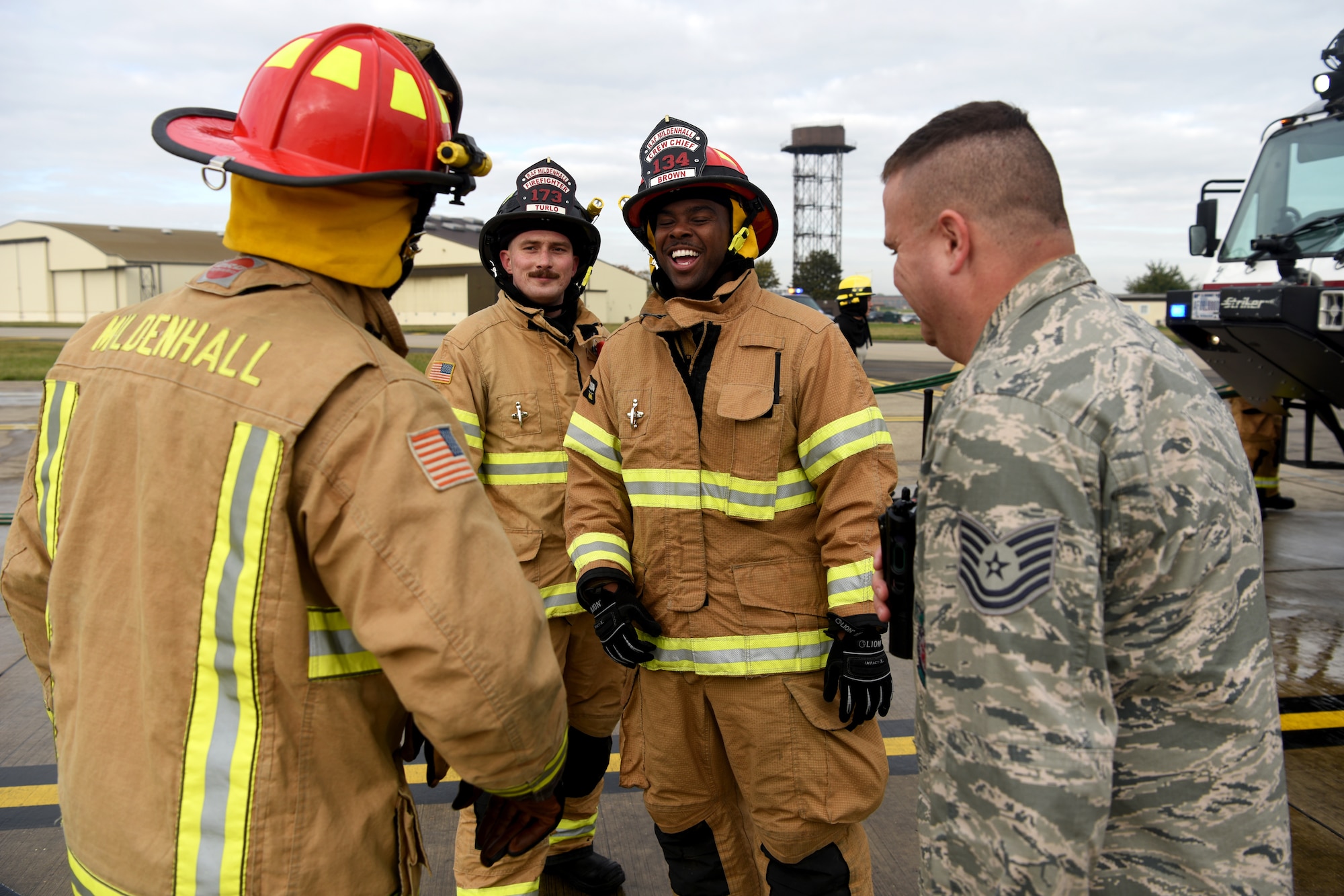 Firefighters with the 100th Civil Engineer Squadron take a break and a have a laugh after training simulating a cockpit fire aboard a KC-135 Stratotanker at RAF Mildenhall, England, Oct. 22, 2019. The firefighters had to search for “unaccounted personnel” in and around the aircraft during the simulated fire. (U.S. Air Force photo by Senior Airman Brandon Esau)