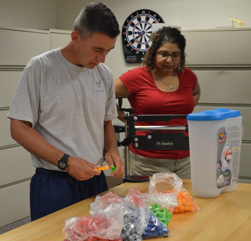 Air Force 1st Lt. Jason Hibbetts tries to connect different shaped pieces together as part of his occupational therapy Aug. 13 at the Brain Injury Rehabilitation Service at Brooke Army Medical Center at Joint Base San Antonio-Fort Sam Houston, as occupational therapist Marina LeBlanc looks on. The BIRS provides comprehensive outpatient neurorehabilitation for service members, family members and military retirees who are recovering from a stroke or other brain injuries using an interdisciplinary approach including physical therapy, occupational therapy, speech language pathology, recreational therapy, psychology, neuropsychology and case management. (Photo by Lori Newman)