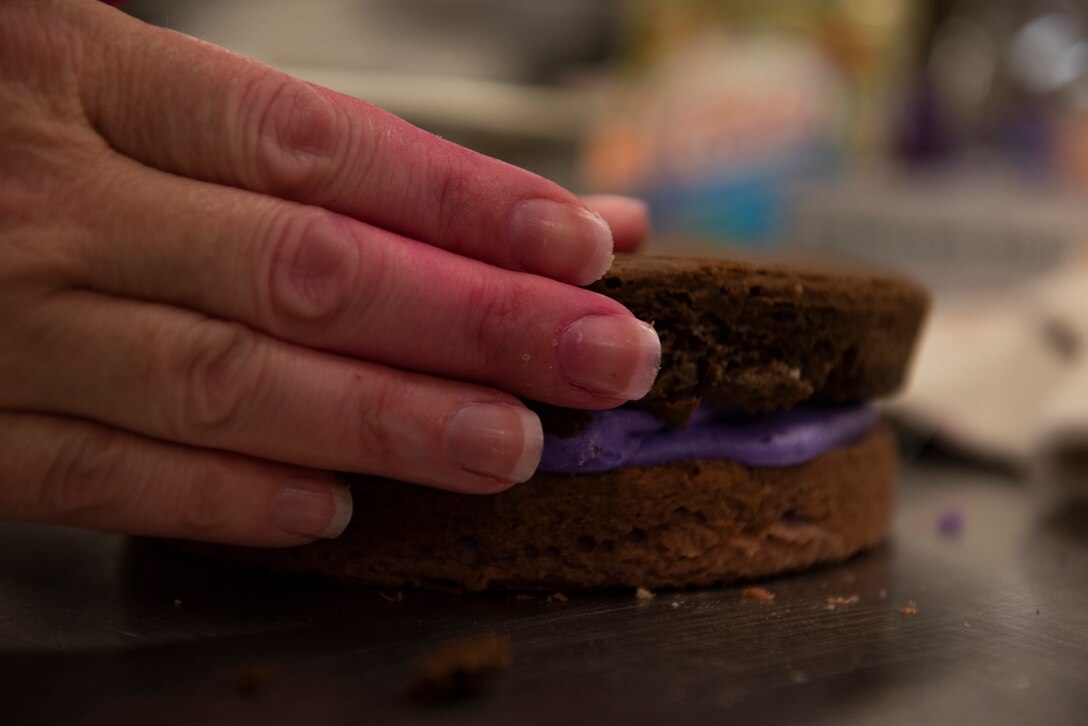 A participant assembles cake layers during a Scary Cake Bake-Off Oct. 23, 2019, at Moody Air Force Base, Ga. The event, hosted by the 23d Force Support Squadron, pitted two teams against each other to bake and design a Halloween-themed cake. In the end, the three judges declared Ight Imma Head Out the winning team. (U.S. Air Force photo by Airman Elijah M. Dority)