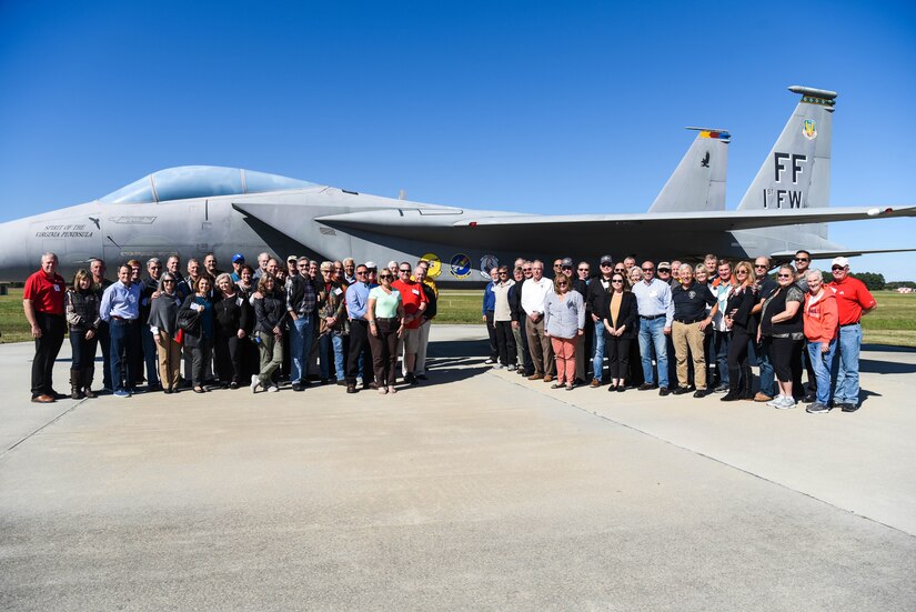 1st Fighter Wing Alumni pose with an F-15 Eagle static display after returning to celebrate their past while looking to the future during the 1st Fighter Wing Association Reunion at Joint Base Langley-Eustis, Virginia, Oct. 18, 2019. During the visit, attendees got an up close look at a U.S. Air Force F-22 Raptor aircraft, received a mission brief and met with current 1 FW leadership. In attendance were former pilots and maintainers of the 1 FW, along with their spouses. (U.S. Air Force photo by Airman 1st Class Marcus M. Bullock)