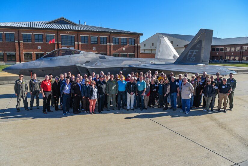1st Fighter Wing Alumni pose with a U.S. Air Force F-22 Raptor aircraft during the 1st Fighter Wing Association Reunion at Joint Base Langley-Eustis, Virginia, Oct. 18, 2019. During the visit, attendees got an up close look at a U.S. Air Force F-22 Raptor aircraft, received a mission brief and met with current 1 FW leadership. In attendance were former pilots and maintainers of the 1 FW, along with their spouses. (U.S. Air Force photo by Airman 1st Class Marcus M. Bullock)
