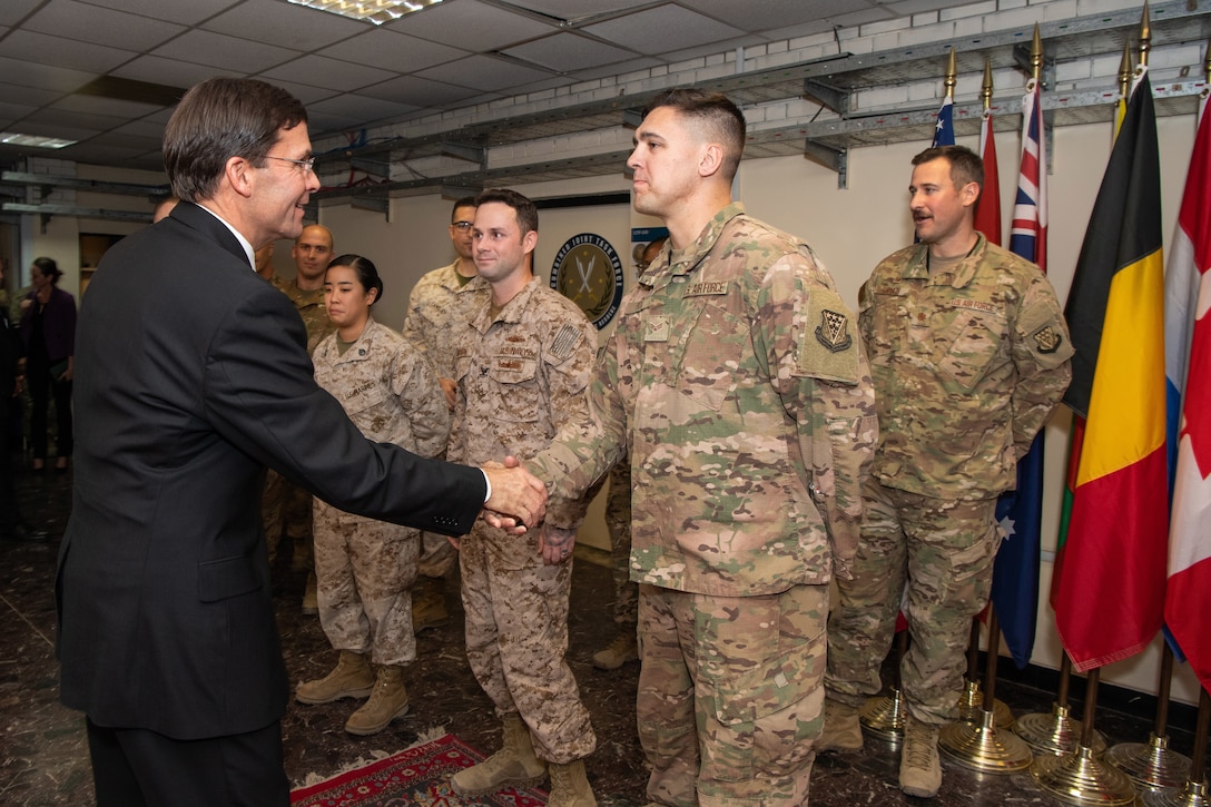 Defense Secretary Dr. Mark T. Esper presents coins to service members.