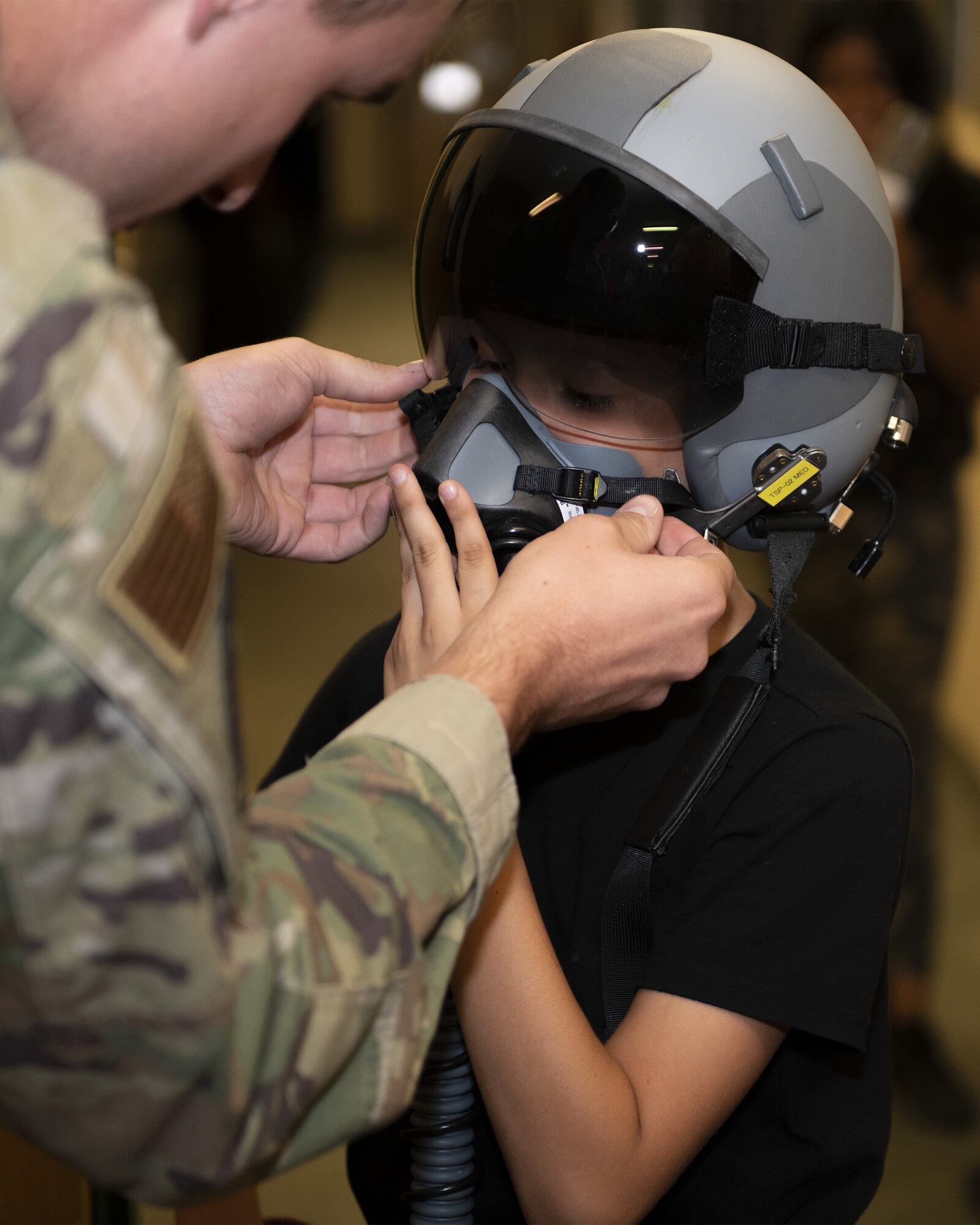 Kenneth Allen, a member of the Childhelp program, dons a pilot helmet at the 56th Operation Support Squadron Aircrew Flight Equipment during the Childhelp Kids Day of Hope tour Oct. 16, 2019, at Luke Air Force Base, Ariz.