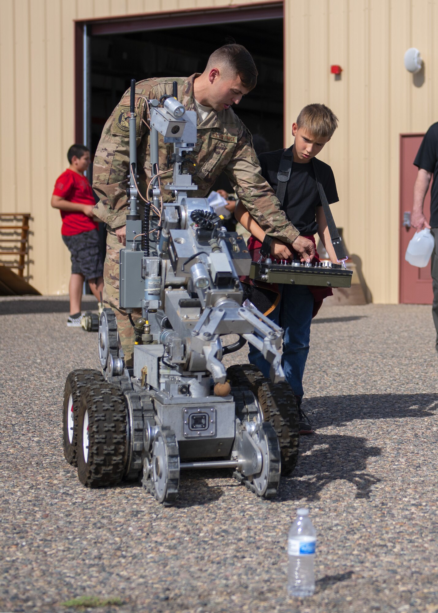 Airman 1st Class Jacob Turcotte, 56th Civil Engineer Squadron explosive ordnance disposal team member, instructs Kenneth Allen, a member of the Childhelp program, on how to use an Andros 16 bomb disposal robot during the Childhelp Kids Day of Hope tour Oct. 16, 2019, at Luke Air Force Base, Ariz.