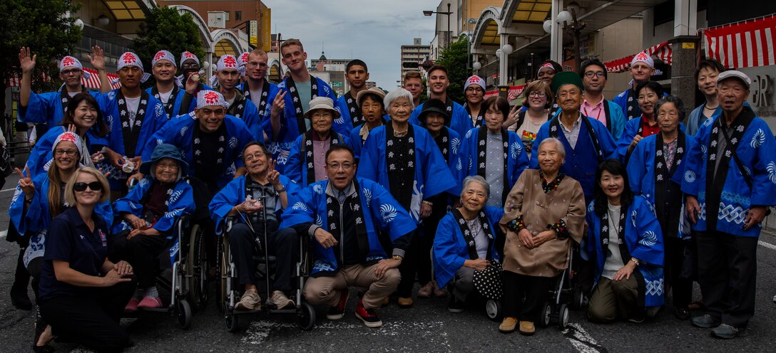 U.S. Marines from Marine Corps Air Station Iwakuni and local Japanese volunteers pose for a group photo during the 63rd Iwakuni Matsuri parade in Iwakuni City, Japan, Oct. 20, 2019. The Iwakuni Matsuri Festival is an annual festival and parade that features the local community and local organizations coming together to promote safety and development in the city.