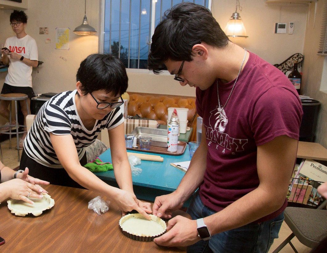 Yukari Niwano, the instructor for the cooking class, which Mari Gregory interprets, teaches one of the students how to mold a pie sheet June 23 at Uruma City. Gregory and Sgt. Maj. Mario Marquez, the III Marine Expeditionary Force sergeant major, have partnered up since July 2017 to provide time and space for the shared Okinawan community to understand each other and exchange friendship.