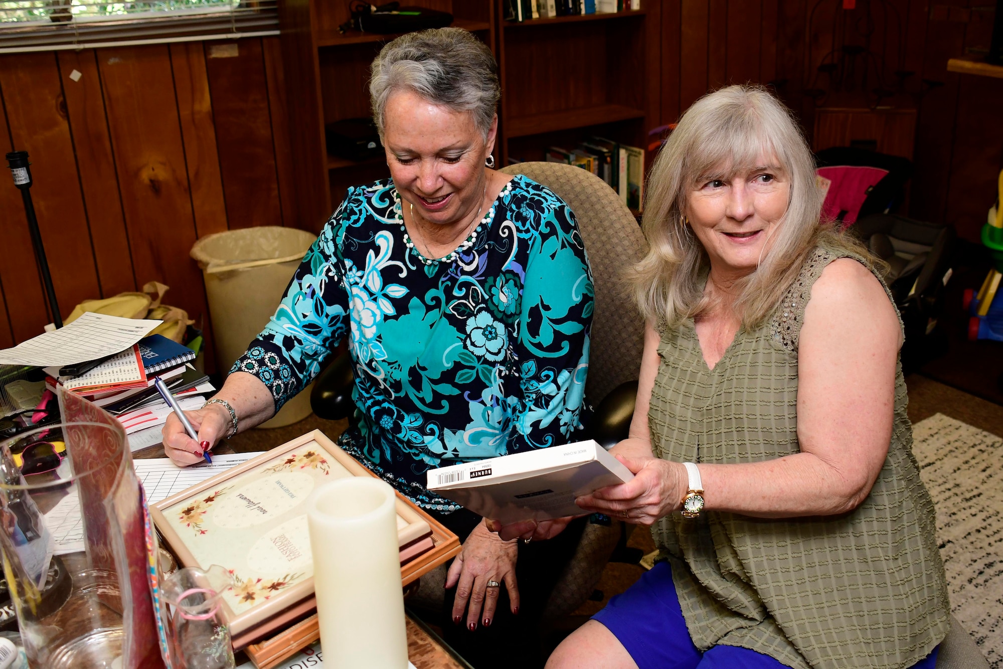 Marcia Miller, a thrift shop volunteer, left, receives an item from a consigner at the Dobbins Thrift Shop on April 11, 2019. The Dobbins Thrift Shop accepts goods via two methods: donations and consignment. (U.S. Air Force photo/Tech. Sgt. Andrew Park)