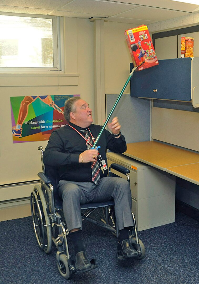 DLA Logistics Information Services Director Ray Zingaretti navigates cubicle life at the wheelchair users station.