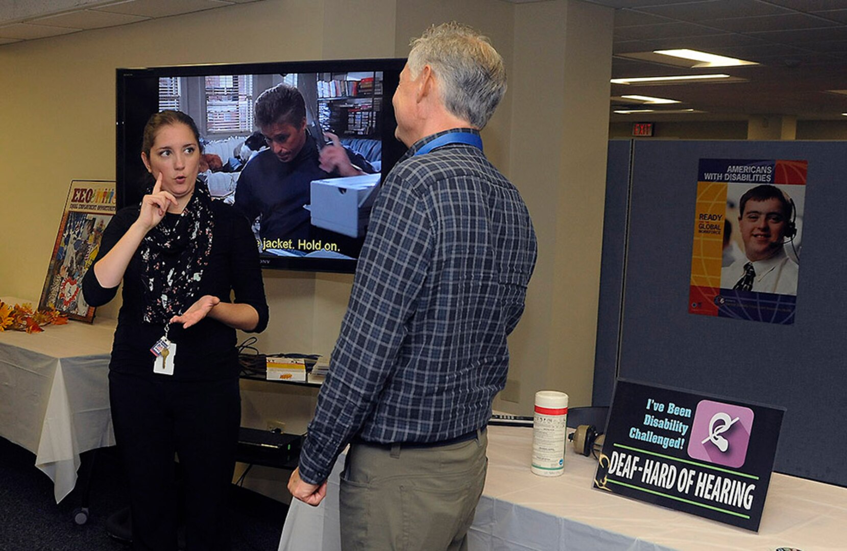 DLA Disposition Services Interpreter Stacy Marsala communicates with event attendees via sign language at the Disability Challenge’s deaf and hard of hearing station.