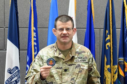 Lt. Col. Caragher, Deputy G-3, 85th U.S. Army Support Command, shows his Army Physical Fitness Badge during a weekend battle assembly, October 20, 2019.