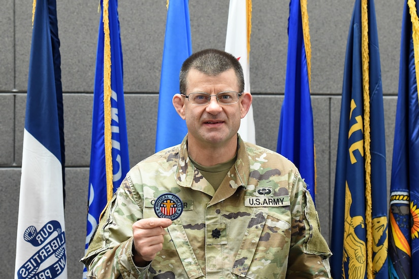 Lt. Col. Caragher, Deputy G-3, 85th U.S. Army Support Command, shows his Army Physical Fitness Badge during a weekend battle assembly, October 20, 2019.