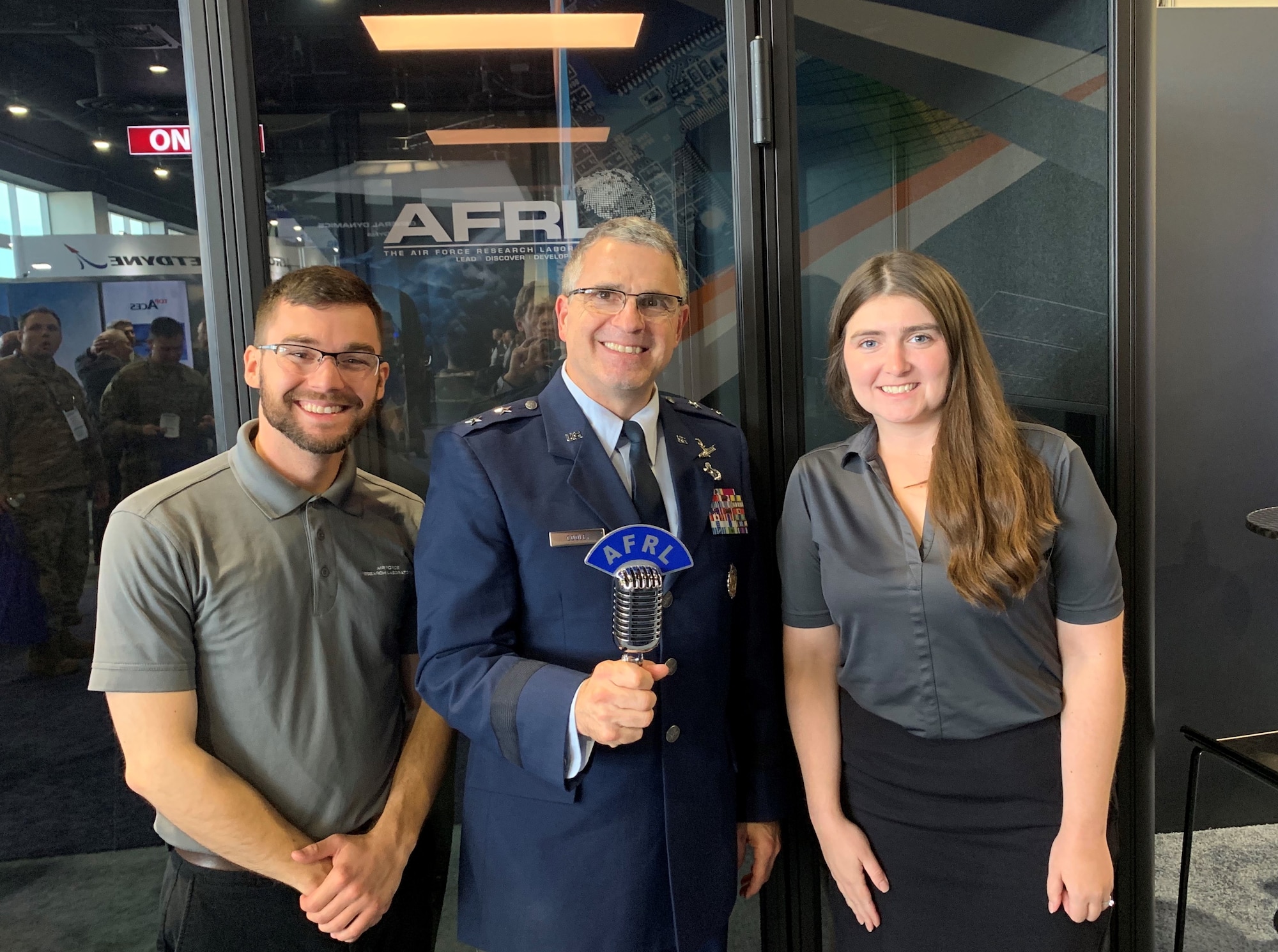 Maj. Gen. William Cooley, commander of the Air Force Research Laboratory, joins AFRL Lab Life podcast co-hosts, Kenneth McNulty and Michele Miller at the Lab Life podcast booth on the floor of the Air Force Association's Air, Space, and Cyber conference exhibit area during the 2019 Air, Space, and Cyber conference. Cooley joined other senior Air Force leaders as guests on the podcast, sharing views on Air Force science and technology growth. (Courtesy photo)