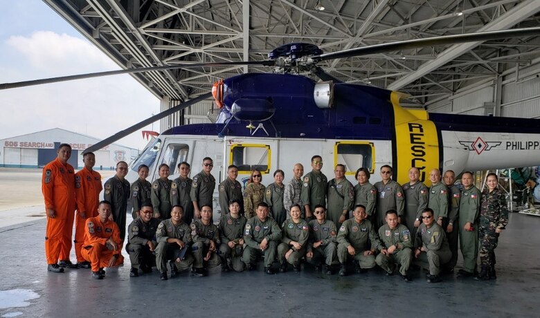 Pacific Air Forces Airmen and Bilateral Subject Matter Expert Exchange participants take a photo with a Philippine air force Sikorsky S-76A, Clark Air Base, Philippines, September 11, 2019. (Courtesy photo)