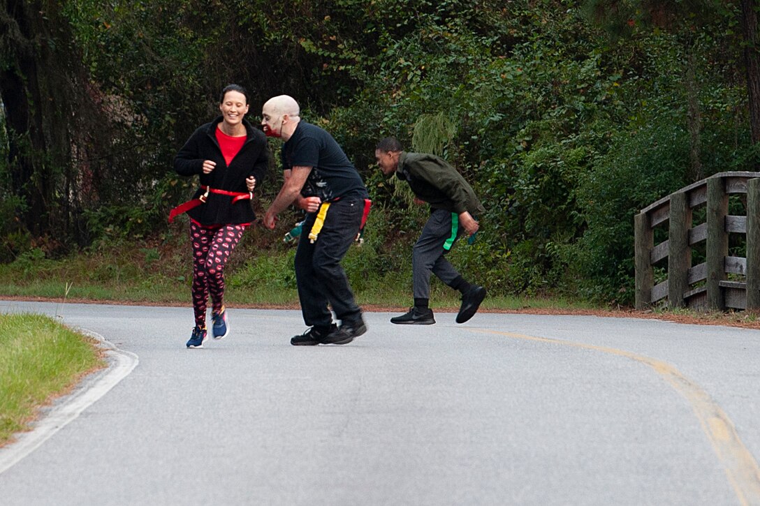 A Zombie Run volunteer chases a participant Oct. 24, 2019, at Moody Air Force Base, Ga. Participants began the run with two flags on their belts to identify their "lives." Each participant was challenged with running from volunteers dressed as zombies, ensuring participants do not lose a "life." (U.S. Air Force photo by Airman 1st Class Jasmine M. Barnes)
