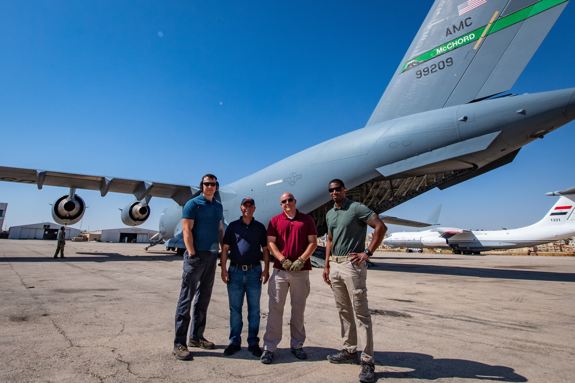 Members of the American Embassy to Jordan, Military Assistance Program, Aerial Logistics Port pose for a picture in front of a U.S. C-17 Globemaster III in Jordan, Oct. 14, 2019. During the team’s time in Jordan they have handled over 370 missions, coordinated logistics for 430 tons of cargo, and manifested over 3,000 passengers in support of State Department diplomatic efforts and Department of Defense training missions such as Exercise Eager Lion, U.S. Central Command’s largest exercise. Pictured are: Staff Sgt. Tony Bellew, Mr. Akram Al Ramone, Tech. Sgt. Kyle Hersel, and Master Sgt. Chester Moore.