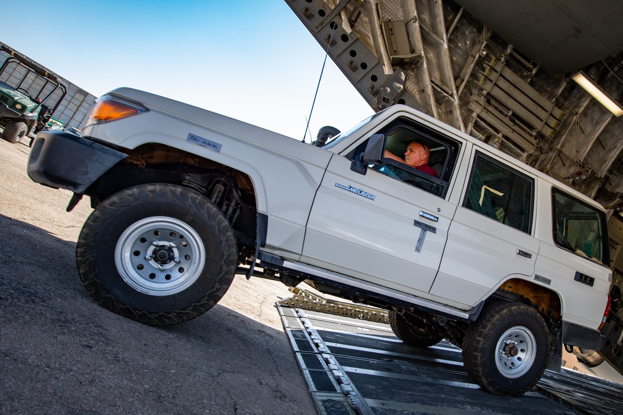 Tech. Sgt. Kyle Hersel, Assistant NCO-in-charge of Air Terminal Operations, Jordan Port, 387th Air Expeditionary Squadron, drives a vehicle off of a U.S. Air Force C-17 Globemaster III in Jordan, Oct. 14, 2019. The port provides aerial logistics for the American Embassy to Jordan through the Military Assistance Program, handling cargo and passenger movement in support of State Department efforts.