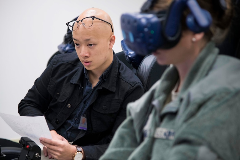 Derrick Ng, NASA aerospace engineer intern, observes a future student of Pilot Training Next version three during a virtual reality flight at Joint Base San Antonio-Randolph, Texas, Oct. 22, 2019, as part of a collaborative research agreement between PTN and NASA. The partnership will focus on biometric data collection and the application of emerging technology into PTN curriculum that will innovate the student pilot learning environment. (U.S. Air Force photo by Sean M. Worrell)