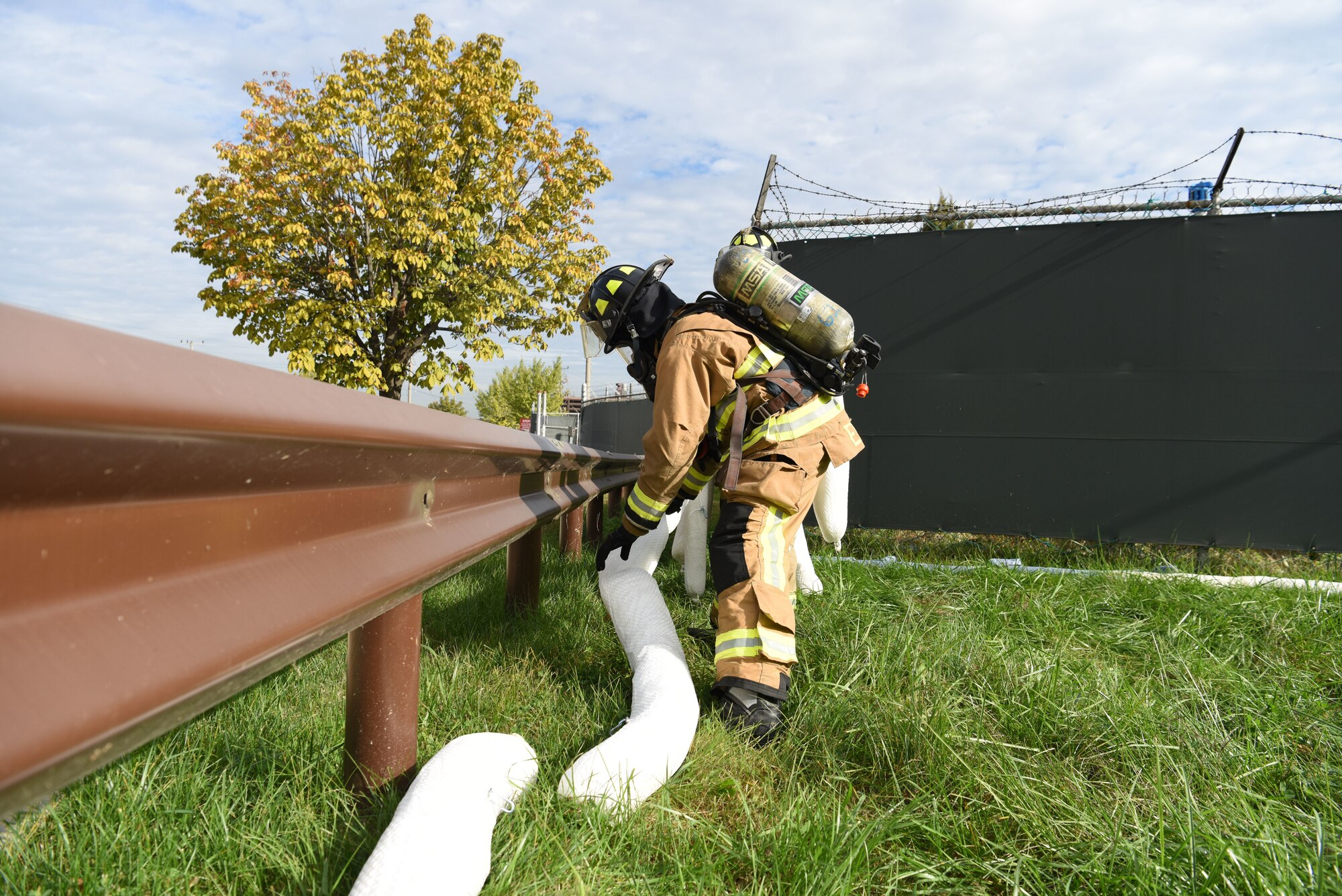 Fire fighters from the 51st Civil Engineer Squadron lay down long rolls of fuel absorbent pads to keep the fuel from leaking any further during an exercise at Osan Air Base, Republic of Korea, October 18, 2019. The main task of the exercise is to contain the fuel spill before it can reach the rest of the base or potentially leak off base. Once contained, the fuel is pumped out of containment reservoirs and clean-up is performed. (U.S. Air Force photo by Staff Sgt. Benjamin Bugenig)