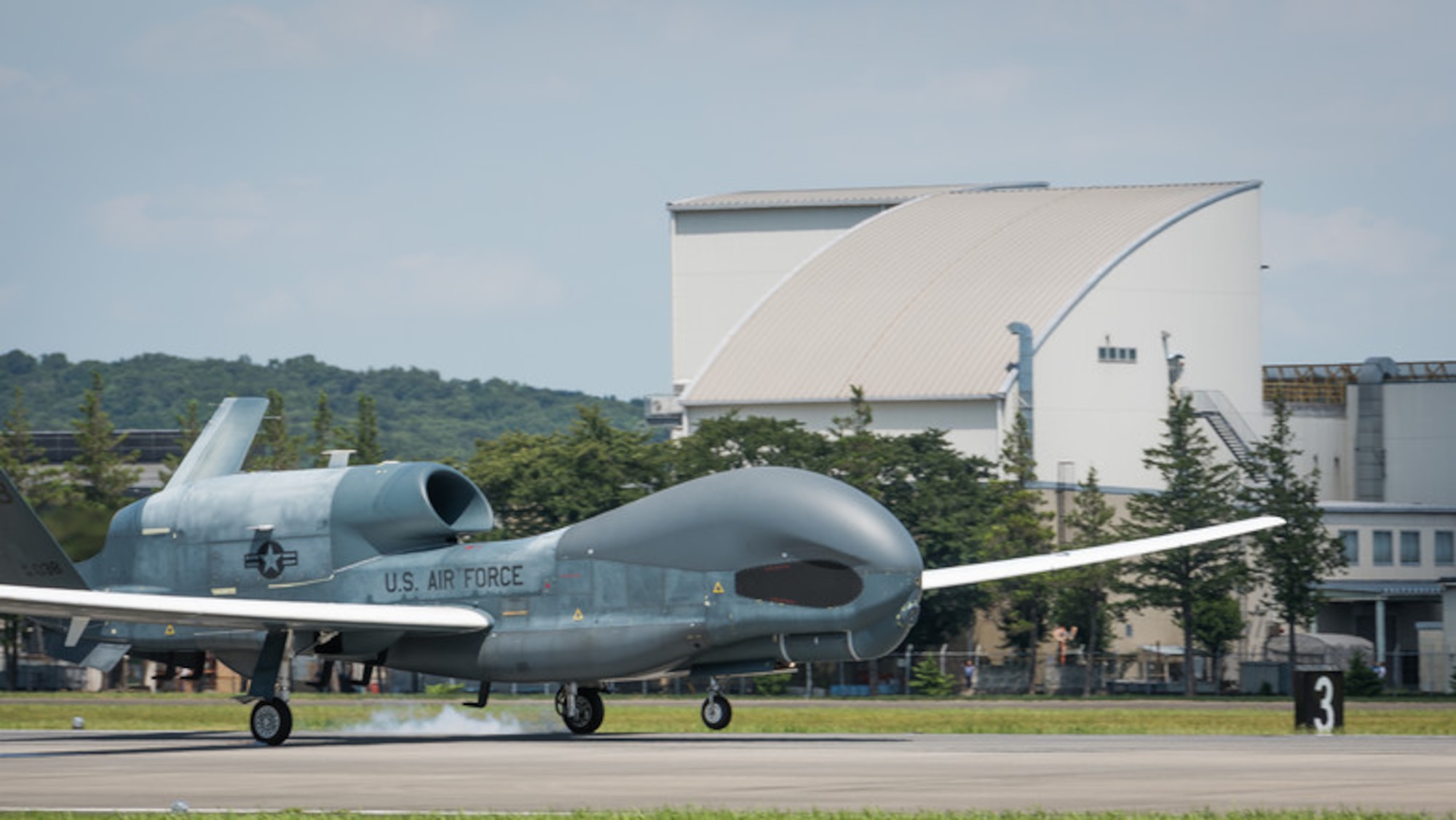 An RQ-4 Global Hawk, assigned to the 319th Operations Group, Detachment 1, Andersen Air Force Base, Guam, lands at Yokota Air Base, Japan, Aug. 5, 2019, for a rotational deployment. The movement maintains operations for Global Hawks during months of inclement weather endured at Andersen AFB, such as typhoons and other scenarios which have the potential to hinder readiness. (U.S. Air Force photo by Senior Airman Juan Torres)