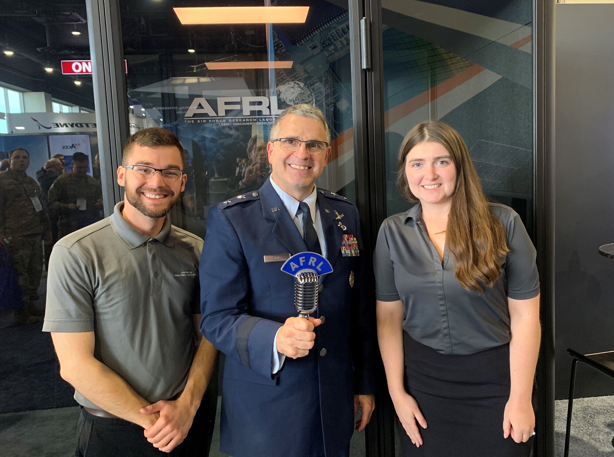 Maj. Gen. William Cooley, commander of the Air Force Research Laboratory, joins AFRL Lab Life podcast co-hosts, Kenneth McNulty and Michele Miller at the Lab Life podcast booth on the floor of the Air Force Association's Air, Space, and Cyber conference exhibit area during the 2019 Air, Space, and Cyber conference. Cooley joined other senior Air Force leaders as guests on the podcast, sharing views on Air Force science and technology growth. (Courtesy photo)