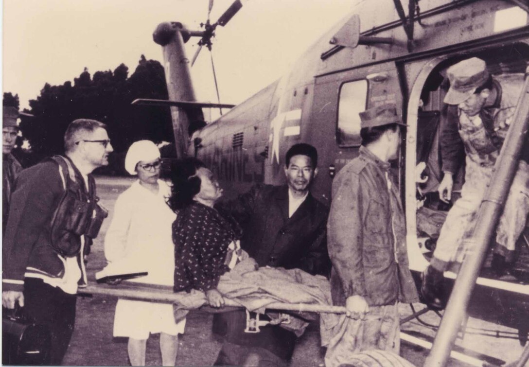 1960年ごろ、緊急患者を軍用機で運ぶアドベンチスト・メディカルセンターの職員。ジョージ・マッカーサー米海兵隊大尉の祖父は宣教師として戦後の沖縄を訪れ、同時に医師として、沖縄県民のため尽力してきました。