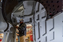 Photo of Tobyhanna employee installing gun port shield guide rails.