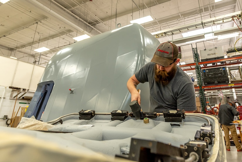 Photo of Tobyhanna employee installing the locking mechanism for the weather shield door.