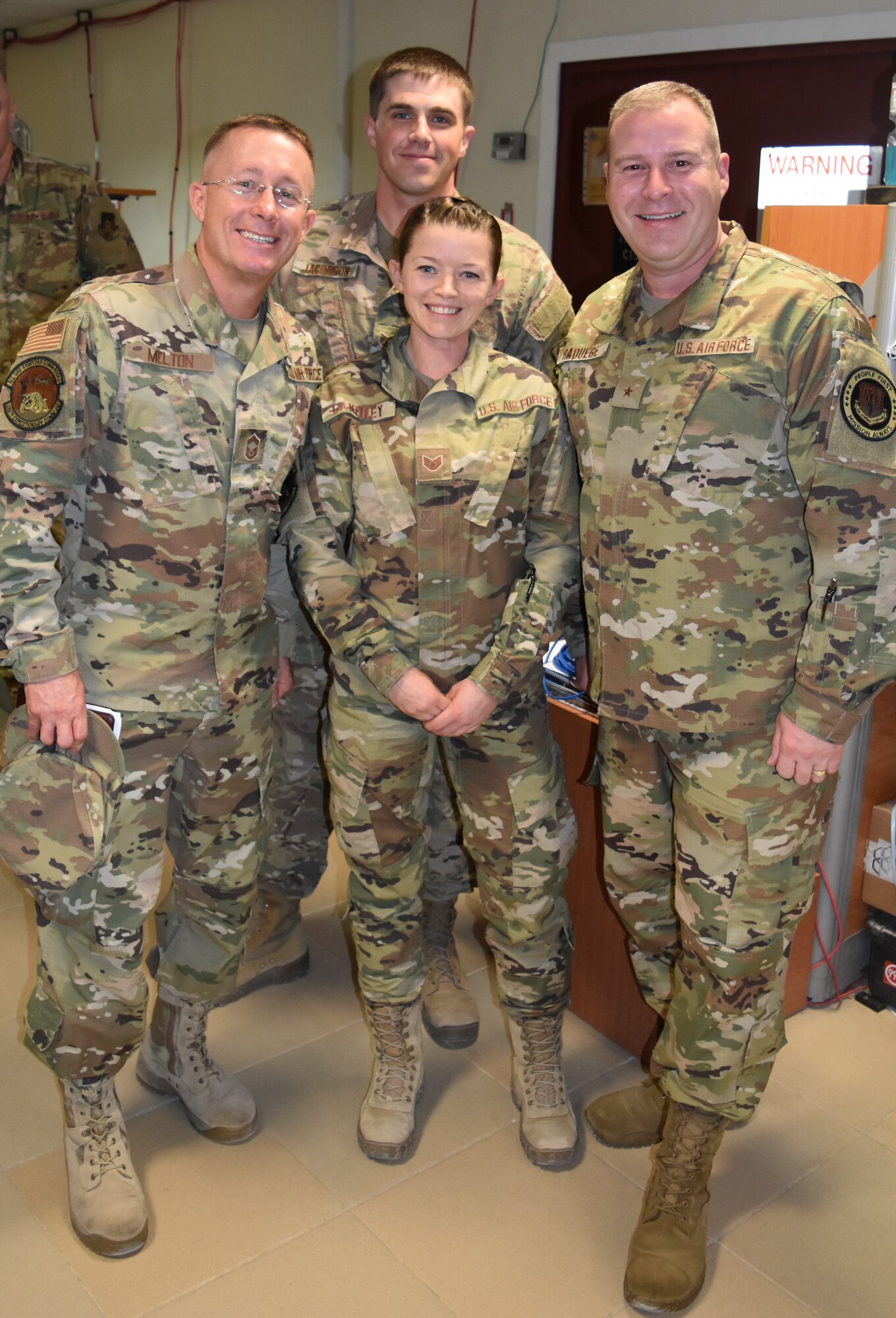 U.S. Air Force Brig. Gen. Chad Raduege, Air Combat Command director of cyberspace and information dominance, and chief information officer, right, and Chief Master Sgt. Jereme Melton, ACC communications directorate chief, left, takes a photo with Tech. Sgt. Austin Jacobson and Staff Sgt. Gabrielle Landrey from the 386th Expeditionary Communications Squadron, while visiting Ali Al Salem Air Base, Kuwait, Oct. 2, 2019. Raduege and Melton visited Airmen with the 386th Expeditionary Communications Squadron during a stop at ASAB enroute to the Air Forces Central Command A6 Commander's Summit at Al Udeid Air Base, Qatar. (U.S. Air Force photo by Chief Master Sgt. Joseph Hart)