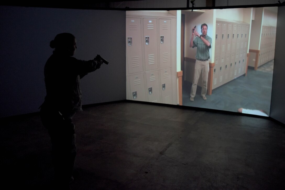 Airman 1st Class Katelyn Powers, 100th Security Forces Squadron response force member, lowers her weapon in respose to a “shoot, no-shoot” scenario in the Firearms Training Simulator at RAF Mildenhall, England, Oct. 21, 2019. New scenarios can be created for training that are specific to that particular installation. (U.S. Air Force photo by Senior Airman Benjamin Cooper)