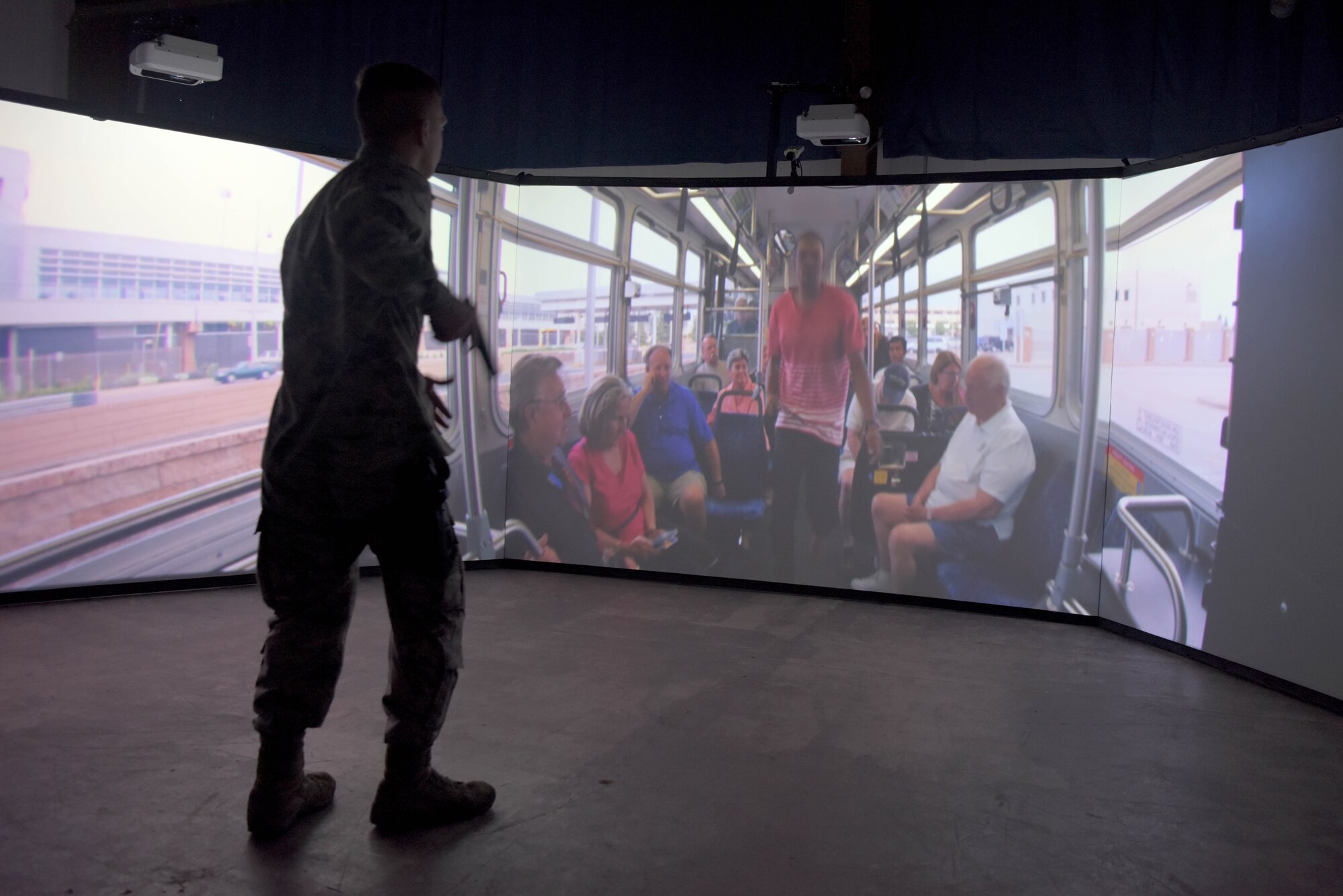 Airman 1st Class Clay Marentis, 100th Security Forces Squadron response force member, draws his simulated weapon during a scenario in the Firearms Training Simulator at RAF Mildenhall, England, Oct. 21, 2019. The simulator is a 300 degree range with five screens, all of which students can interact with. (U.S. Air Force photo by Senior Airman Benjamin Cooper)