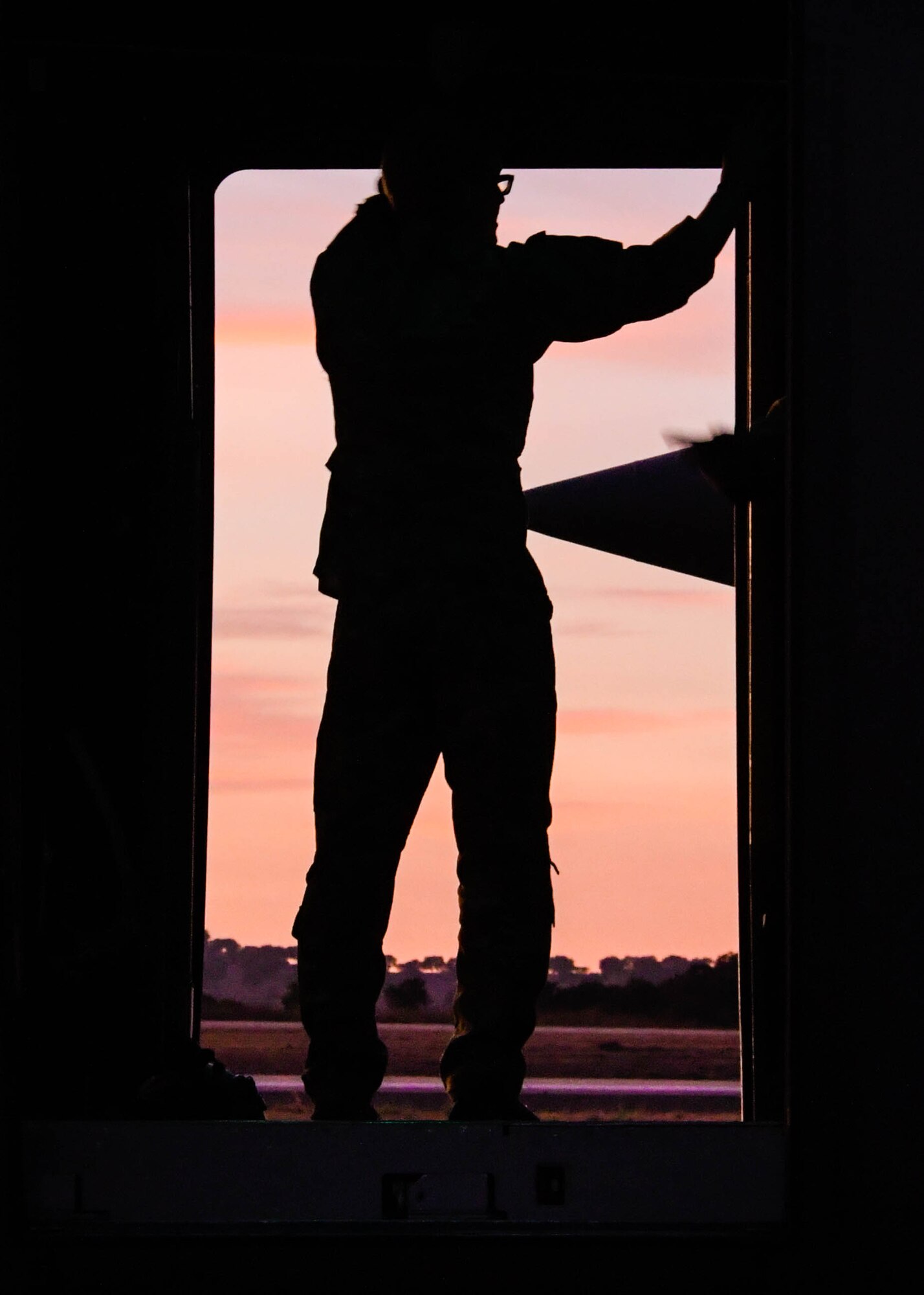 Staff Sgt. Tyler Thomas, a 700th Airlift Squadron loadmaster, surveys the landscape from an open C-130H3 paratroop door during Exercise Real Thaw 2019 at Beja Air Base, Portugal, Oct. 2, 2019. Real Thaw is a Portuguese-led large joint and combined force exercise held annually where Dobbins provided aerial support. (U.S. Air Force photo/Senior Airman Josh Kincaid)