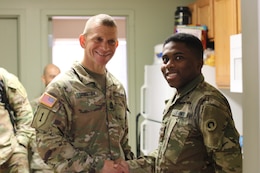 Sgt. Major of the Army Micheal A. Grinston, awards Spc. Khari Johnson, 1st Theater Sustainment Command, a coin of excellence for maintaining high standards, during his visit to Fort Knox, Ky.