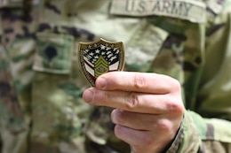 Spc. Ryan Murray, 1st Theater Sustainment Command, holds a coin he received from Sgt. Major of the Army Micheal A. Grinston, during his visit to Fort Knox, Ky. Oct 23, 2019.
