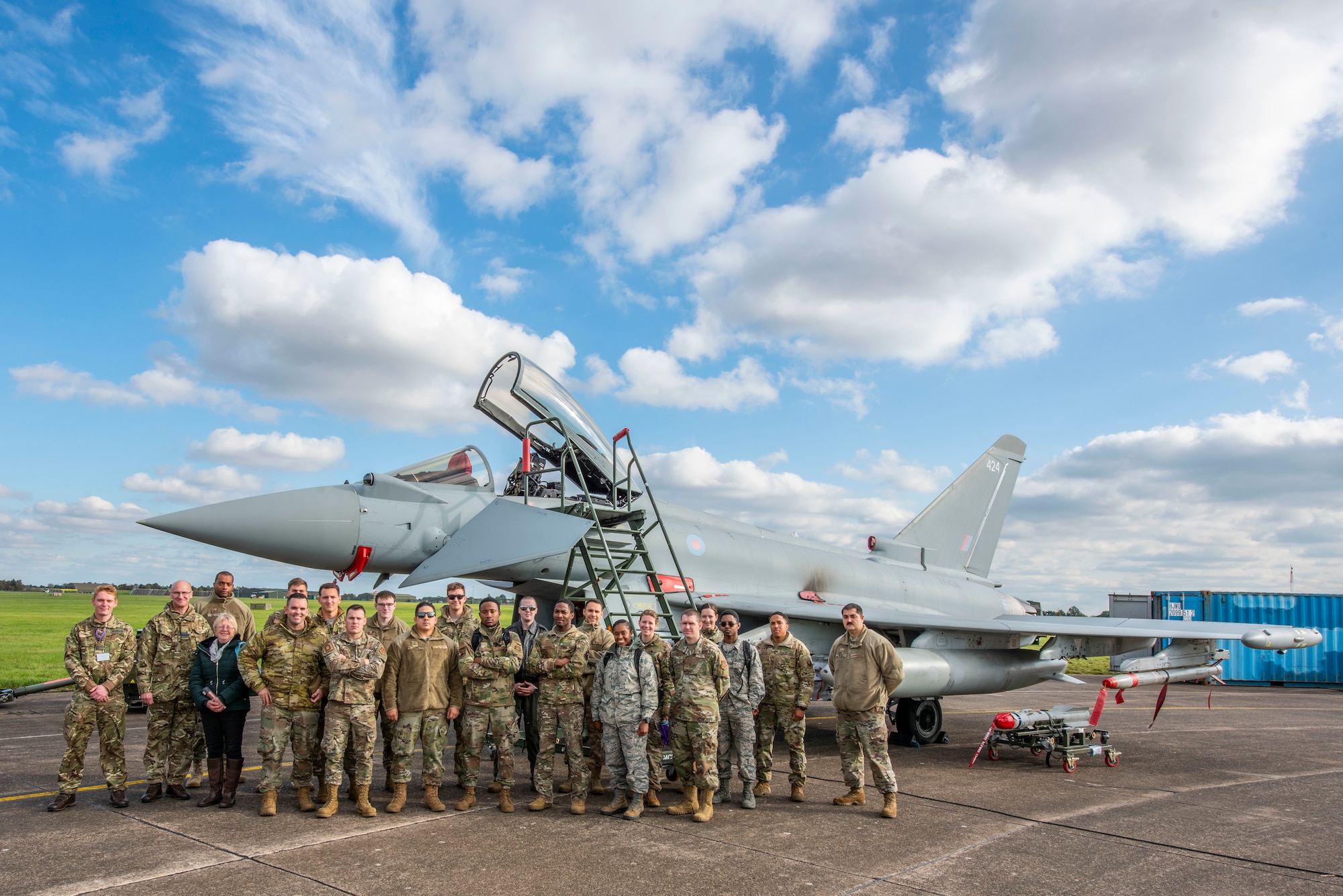 Team Mildenhall Airmen pose for a group photo in front of a Royal Air Force Typhoon FGR.Mk 4 aircraft at RAF Waddington, England, Oct. 22, 2019. The Airmen attended briefings and toured static aircraft displays during the RAF Air Combat Power visit. (U.S. Air Force photo by Airman 1st Class Joseph Barron).