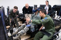 U.S. Air Force Capt. Orion Kellogg, Pilot Training Next instructor, discusses the virtual reality flight of 1st Lt. April Albanese, Det. 24 PTN student, with members of NASA as part of a collaborative research agreement between Air Education and Training Command and NASA Oct. 22 at Joint Base San Antonio-Randolph. The goal of the agreement is to help both AETC and NASA collect physiological and cognitive data and leverage each organization's knowledge and skills to maximize learning potential for individual students.