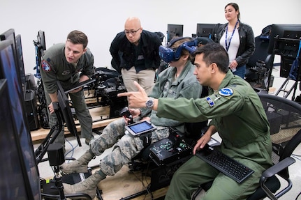 U.S. Air Force Capt. Orion Kellogg, Pilot Training Next instructor, discusses the virtual reality flight of 1st Lt. April Albanese, Det. 24 PTN student, with members of NASA as part of a collaborative research agreement between Air Education and Training Command and NASA Oct. 22 at Joint Base San Antonio-Randolph. The goal of the agreement is to help both AETC and NASA collect physiological and cognitive data and leverage each organization's knowledge and skills to maximize learning potential for individual students.