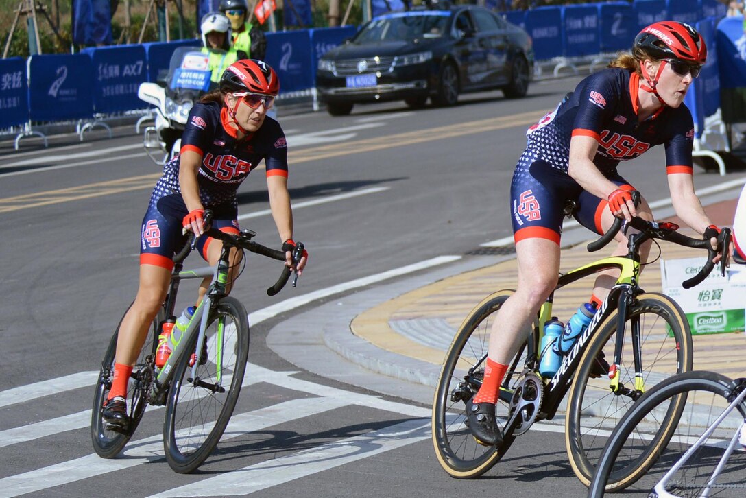 Two cyclists round a corner.