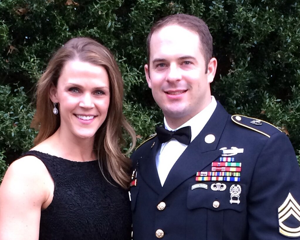 A woman poses with a soldier wearing his dress uniform and bowtie.