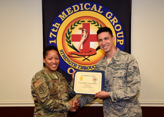 U.S. Air Force Col. Lauren Byrd, 17th Medical Group commander, presents the Medic of the Month Award to Senior Airman Adan Ramirez, 17th MDG aerospace medical technician, at Goodfellow Air Force Base, Texas, Oct. 21, 2019. Ramirez assisted his squadron by creating a slideshow to help with essential training. (U.S. Air Force photo by Airman 1st Class Ethan Sherwood/Released)