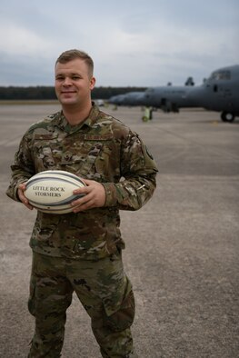 Man stands in front of a C-130J wearing OCPs.
