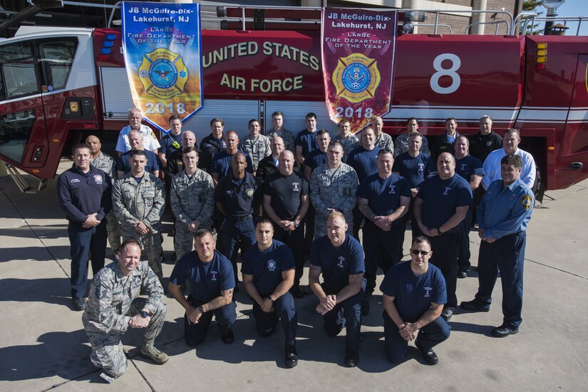 Fire fighters with the 87th Civil Engineer Squadron present their Air Mobility Command and Department of Defense level award banners on Joint Base McGuire-Dix-Lakehurst, New Jersey, Oct. 22, 2019. The department earned the title of the best large fire department across the DOD, beating out all other installations and other military services. (U.S. Air Force photo by Airman 1st Class Ariel Owings)