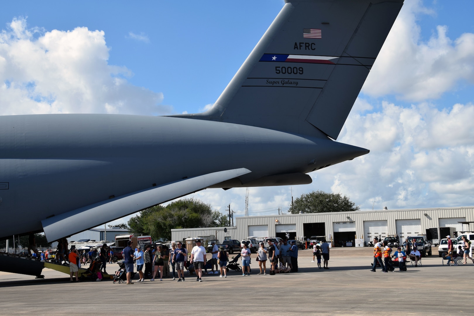 A stream of airshow attendees walk up the rear cargo ramp of a 433rd Airlift Wing C-5M Super Galaxy as it sits on display at the Wings Over Houston Airshow at Ellington Airport in Houston Oct. 20.