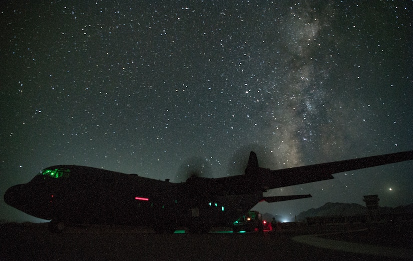 Tactical aircraft sits on a runway against the backdrop of a starry sky.
